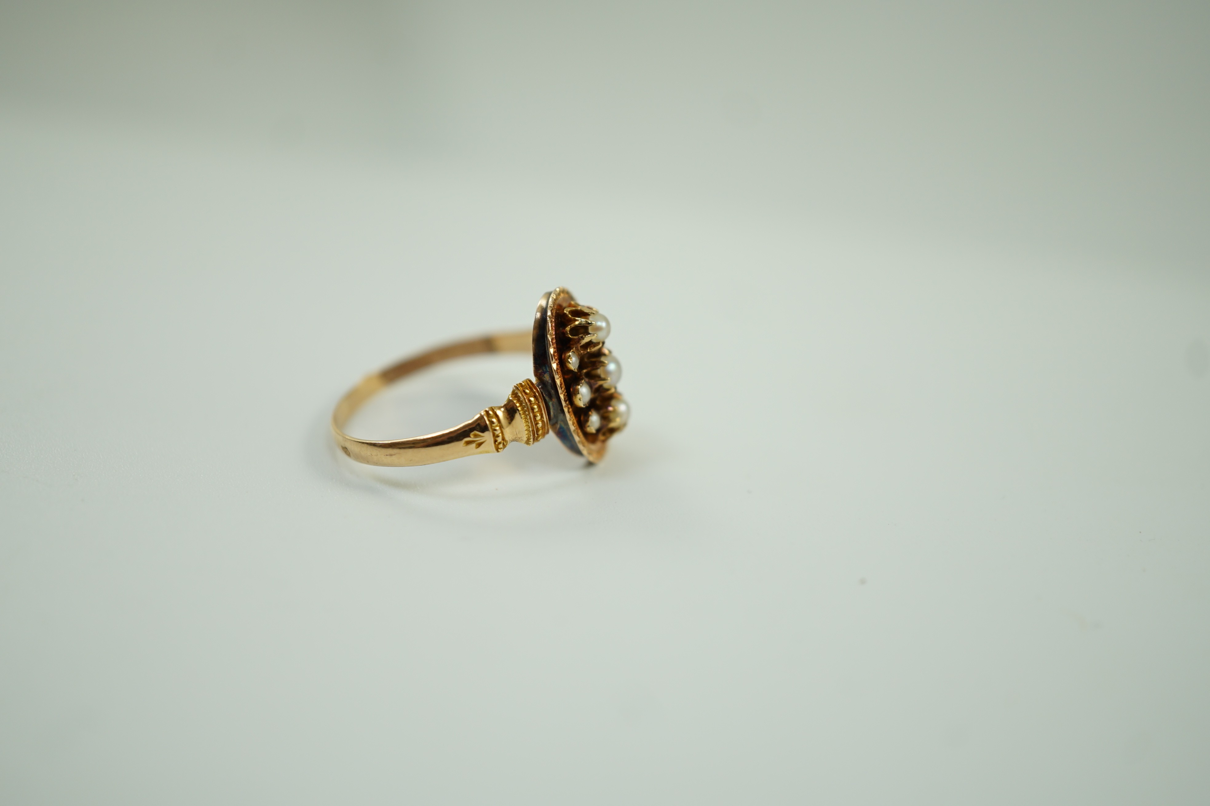 An early 20trh century French yellow metal (18ct poincon mark) and seed pearl cluster set oval ring, size N, gross weight 2.1 grams.